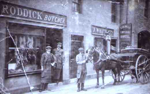 Geordie Roddick standing in his butcher's shop doorway with his son Bert holding the horse, the other man was nicknamed 'Leeks' 